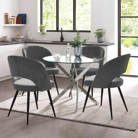 Dining room with a glass table and gray chairs in a modern kitchen.