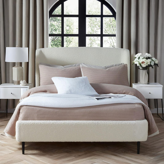 Neatly made bed with pillows and a blanket in a bedroom setting.