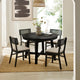 Black round dining table with four chairs in a room with a rug and decor.
