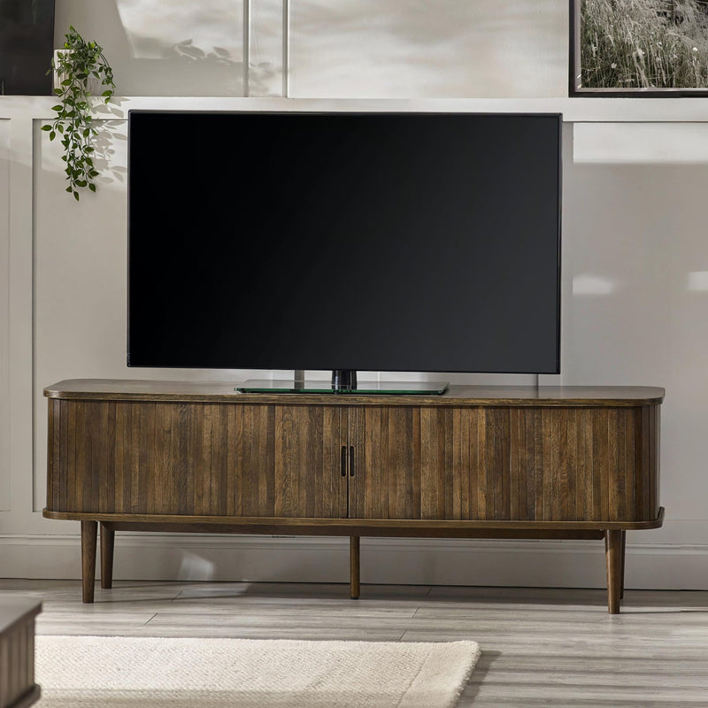 Large flat-screen TV on a wooden stand in a living room setting.