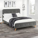 Gray upholstered bed with white bedding and a black blanket in a bedroom setting.