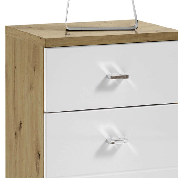 Wooden dresser with white drawers and a silver electronic device on top.