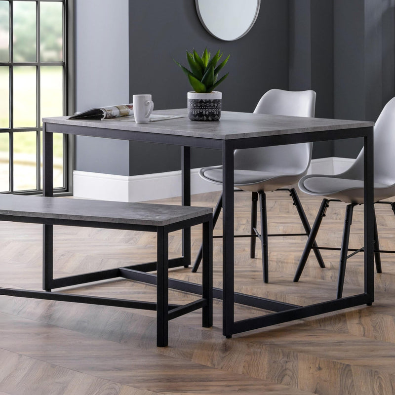 Dining area with a table, chairs, and bench on a wooden floor.