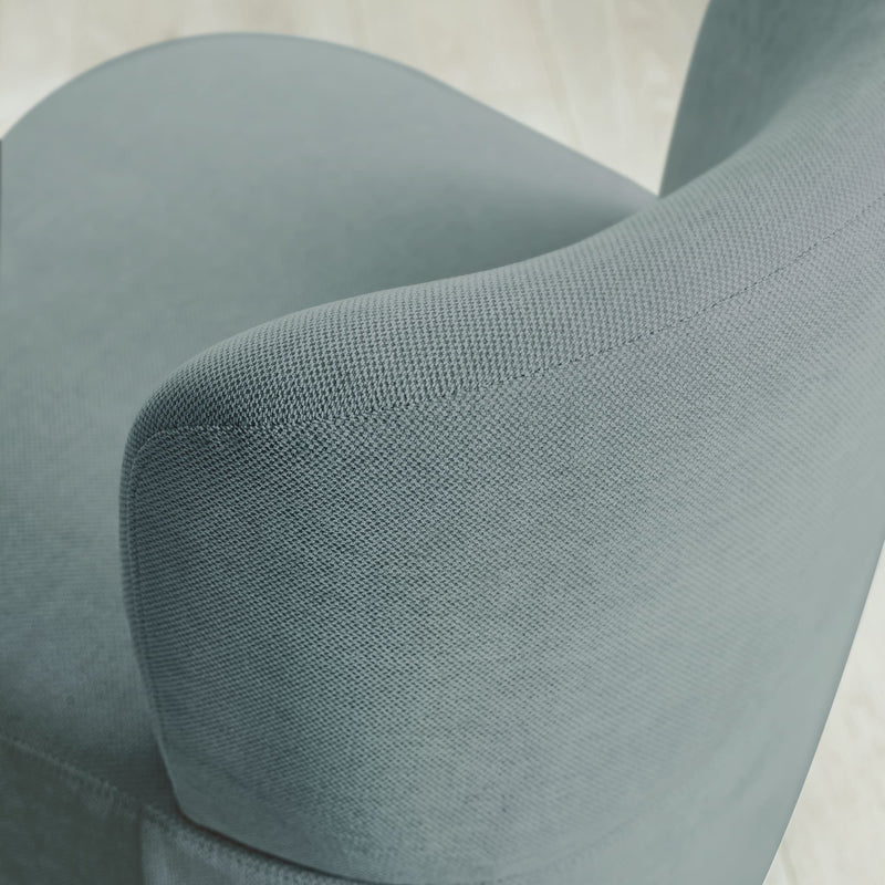 Close-up of a textured teal chair armrest on a light background