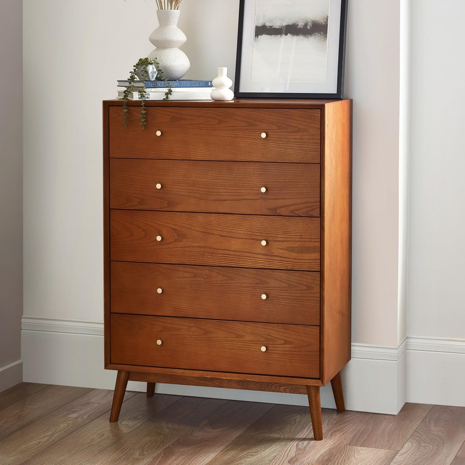 Wooden dresser with four drawers in a room setting.