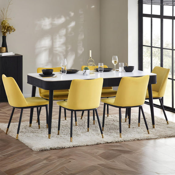Dining room with a black and white table and yellow chairs.