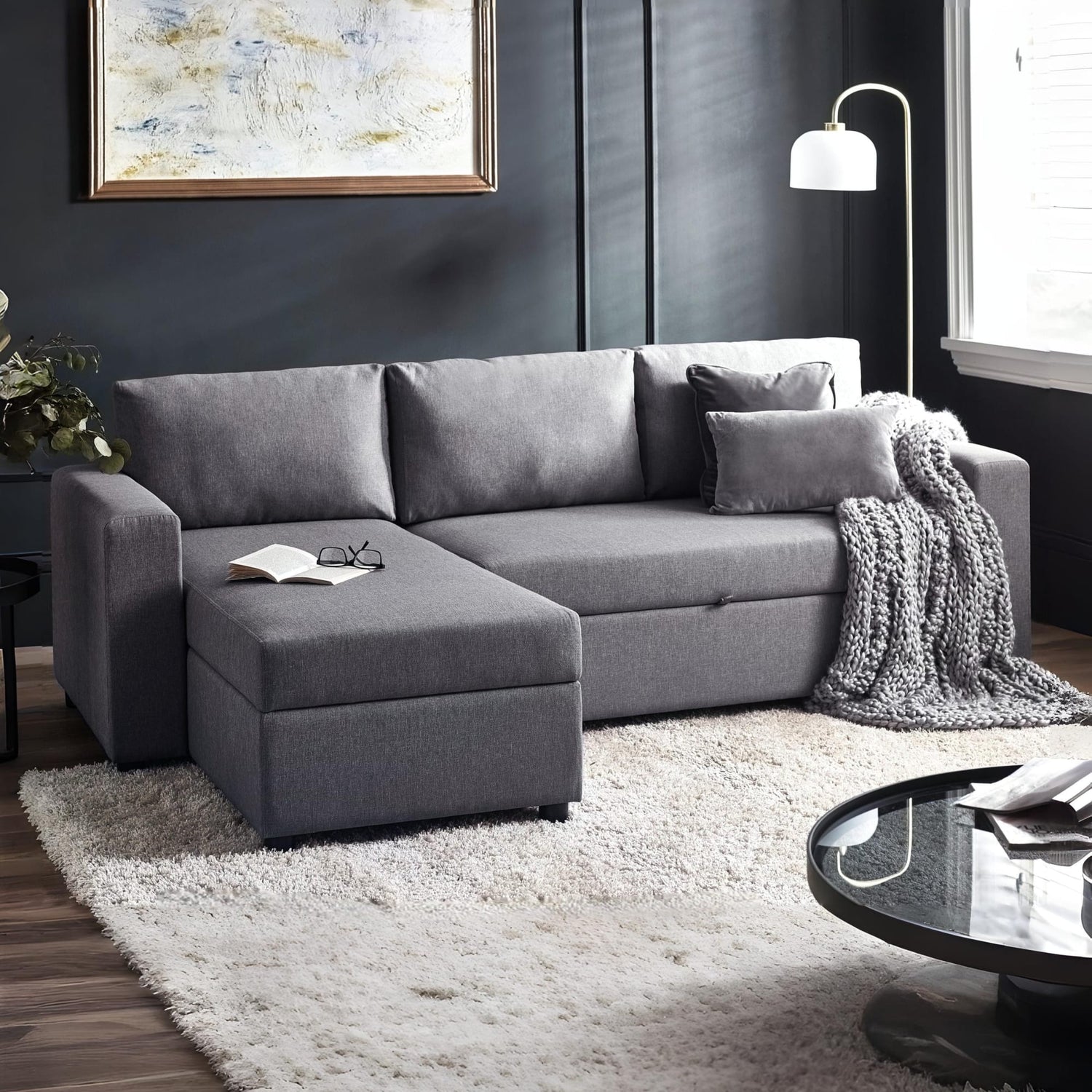 Gray sectional sofa in a living room with a rug and coffee table.