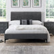 Gray upholstered bed with white bedding in a bedroom setting