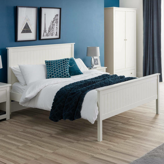 Bedroom with white bed, blue accent pillows, and a wardrobe.