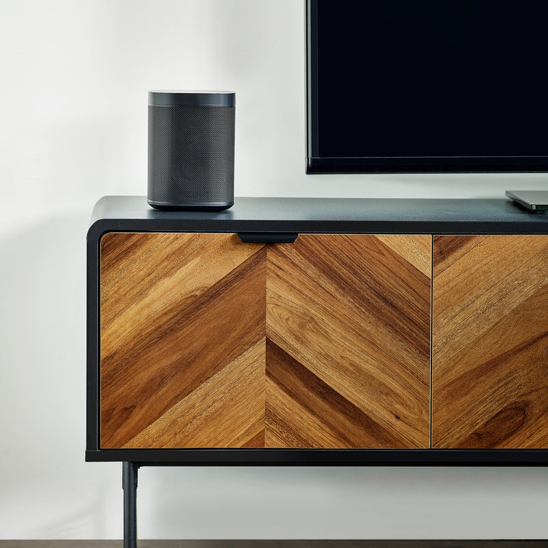 Wooden entertainment console with a television and speaker on a white wall background