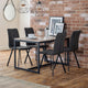 Dining area with a table and four chairs against a brick wall.