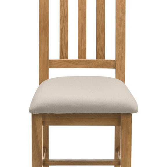 Wooden chair with a beige cushion on a white background