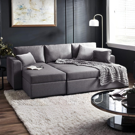 Gray sectional sofa in a living room with a rug and coffee table.