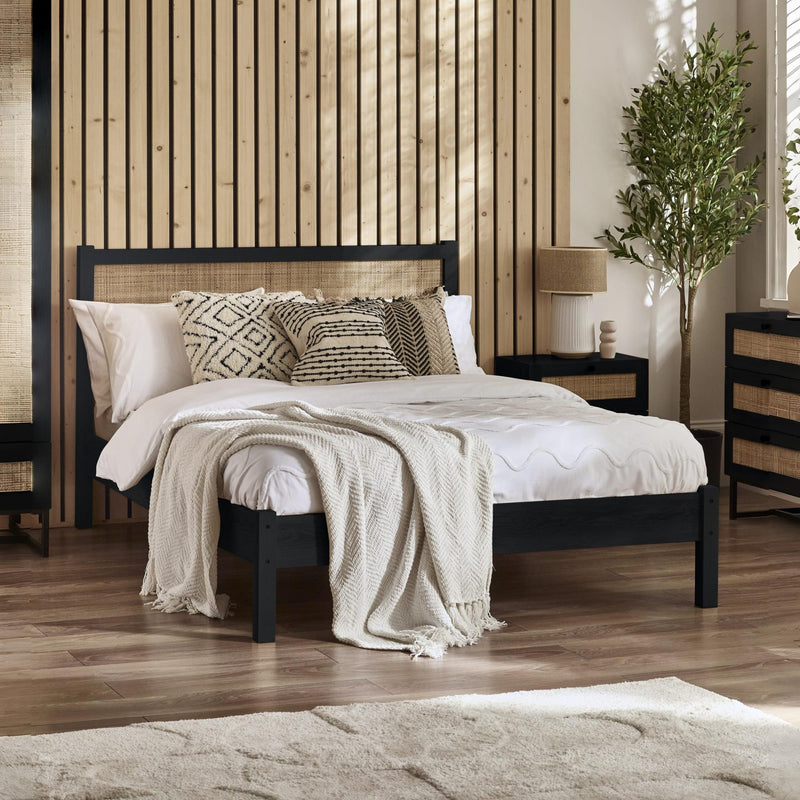 Bedroom with a black bed frame, white bedding, and decorative pillows.