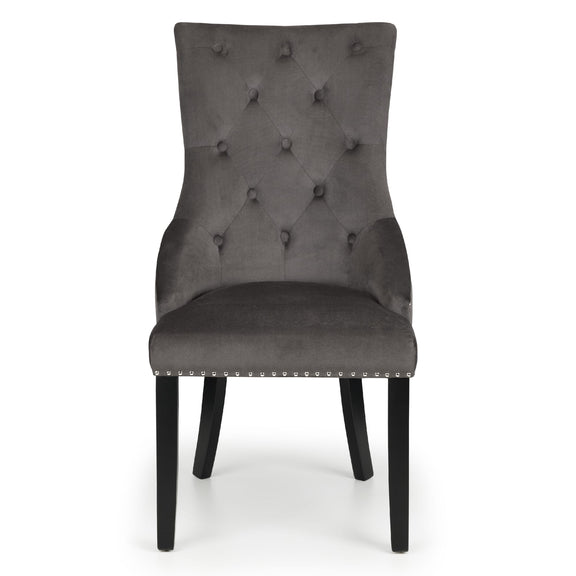 Gray upholstered chair with buttoned backrest on a white background