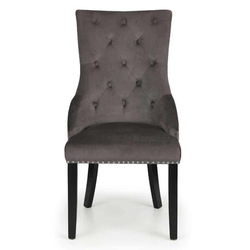 Gray upholstered chair with buttoned backrest on a white background