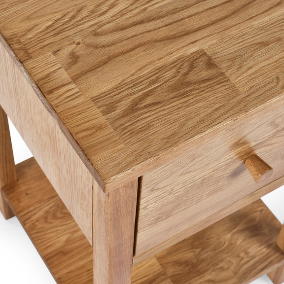 Close-up of a wooden side table with a drawer.
