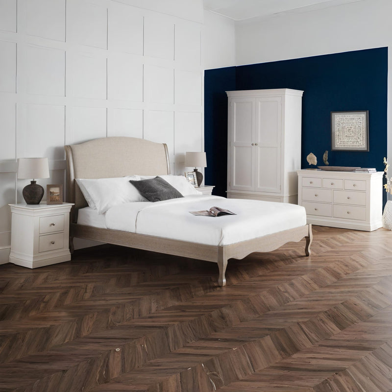 Neatly arranged bedroom with a bed, wardrobe, and dresser.