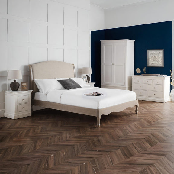 Neatly arranged bedroom with a bed, wardrobe, and dresser.