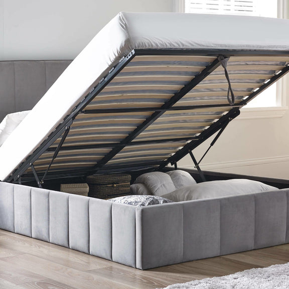 Gray upholstered bed with open headboard showing mattress and support system.