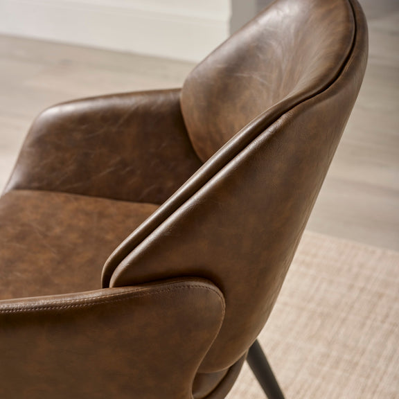 Close-up of a brown leather chair with a blurred background