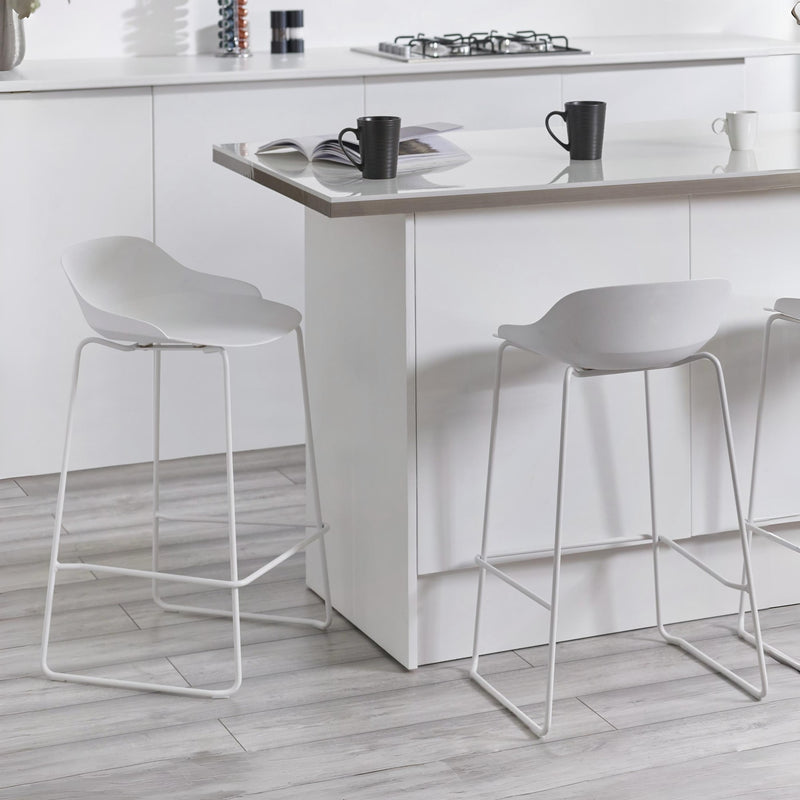 White bar stools in a modern kitchen setting with a white island.