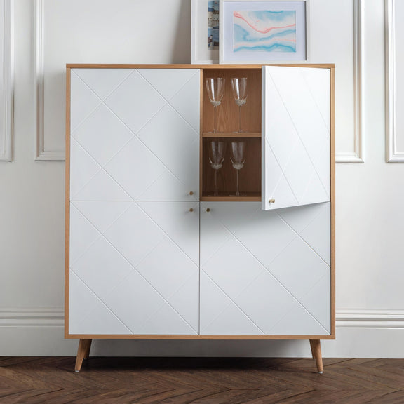 White cabinet with wooden frame and glass shelves against a white wall.