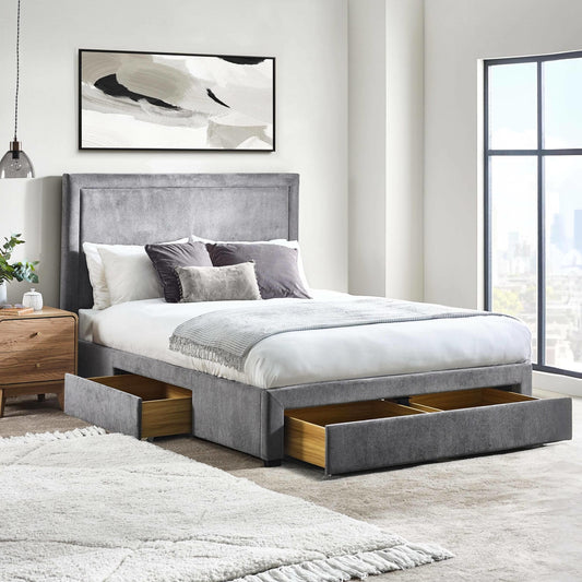 Gray upholstered bed with storage drawers in a modern bedroom setting.