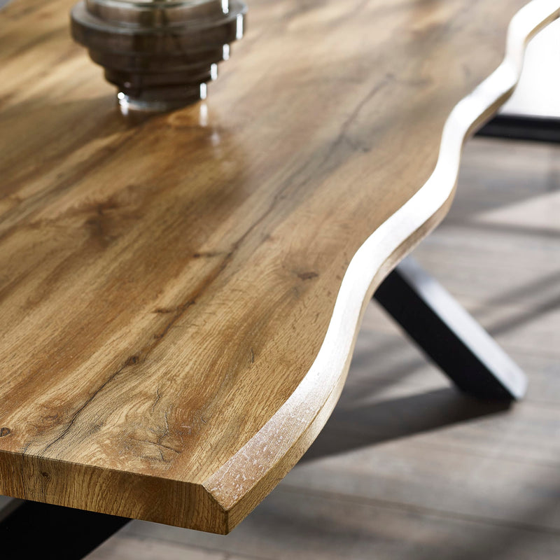 Close-up of a wooden table with a wavy edge on a blurred background