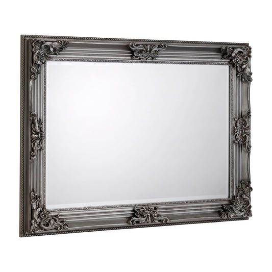 Decorative mirror with an ornate black frame on a white background