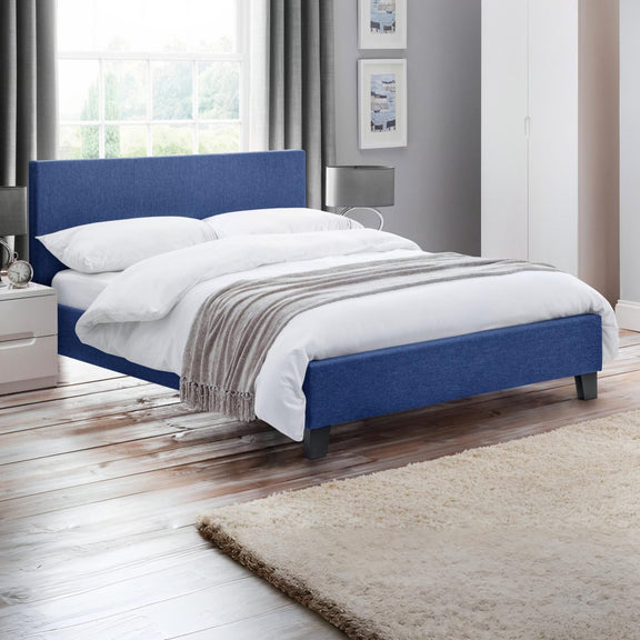 Blue upholstered bed with white bedding in a bedroom setting