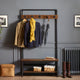 Coat rack with hooks holding coats and an umbrella against a gray wall.