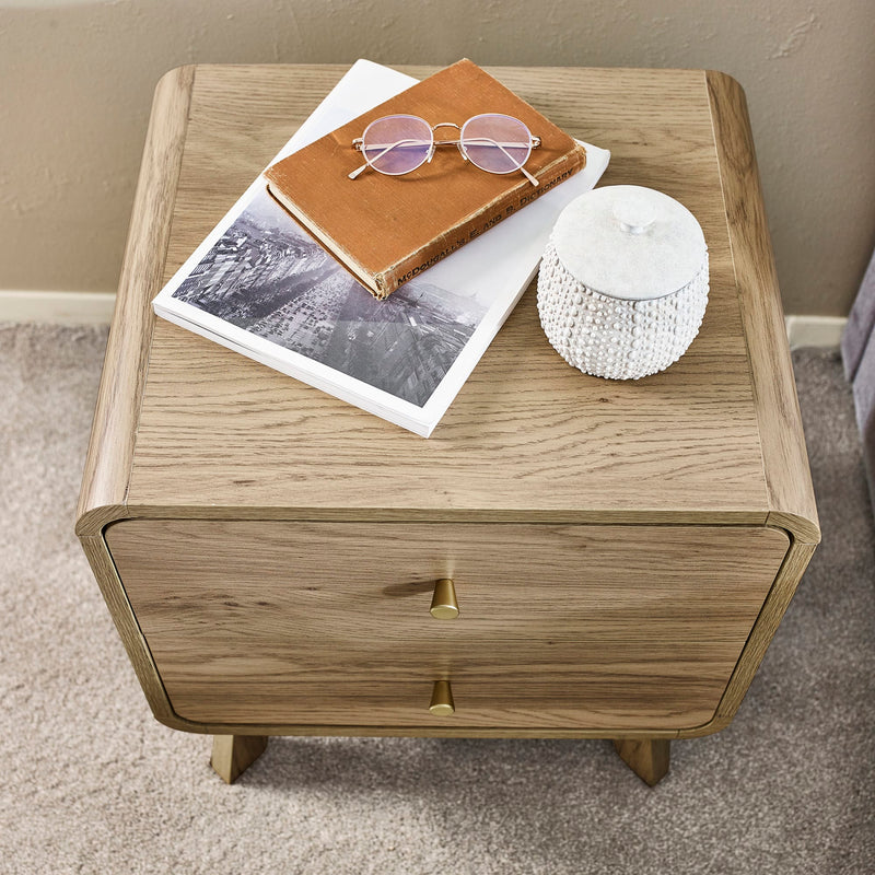 Wooden side table with a drawer, featuring a notebook, sunglasses, and a candle on top.