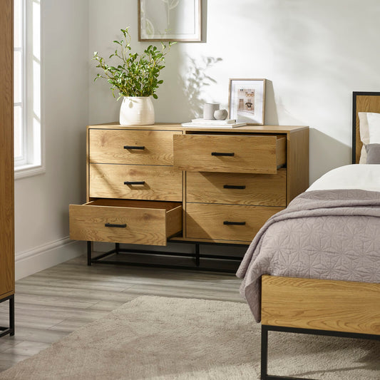Wooden dresser with open drawer in a bedroom setting