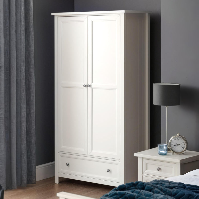 White wardrobe with a gray curtain and nightstand with lamp and clock in a bedroom setting.