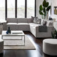 Modern living room with a sectional sofa, coffee table, and decorative items.