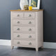 Beige chest of drawers with wooden top against a gray wall