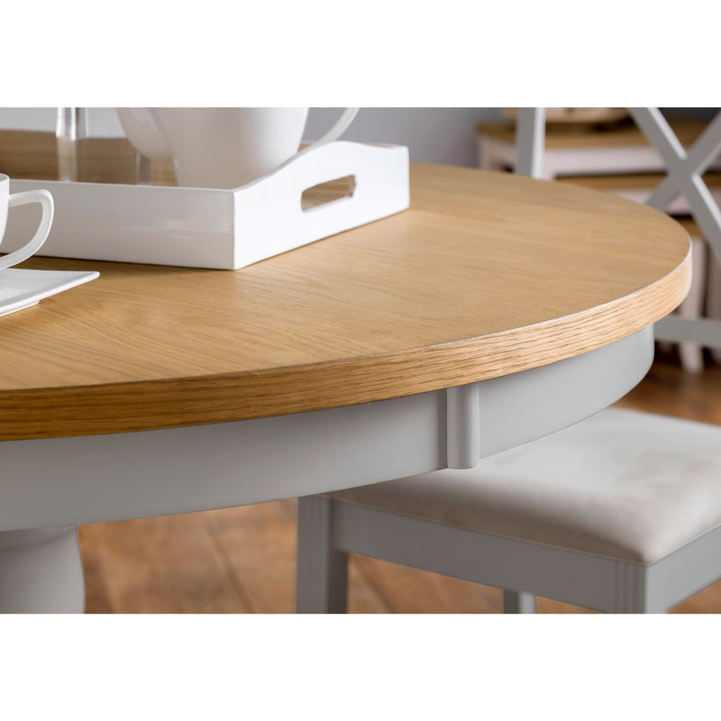 Round wooden table with a white chair in a kitchen setting