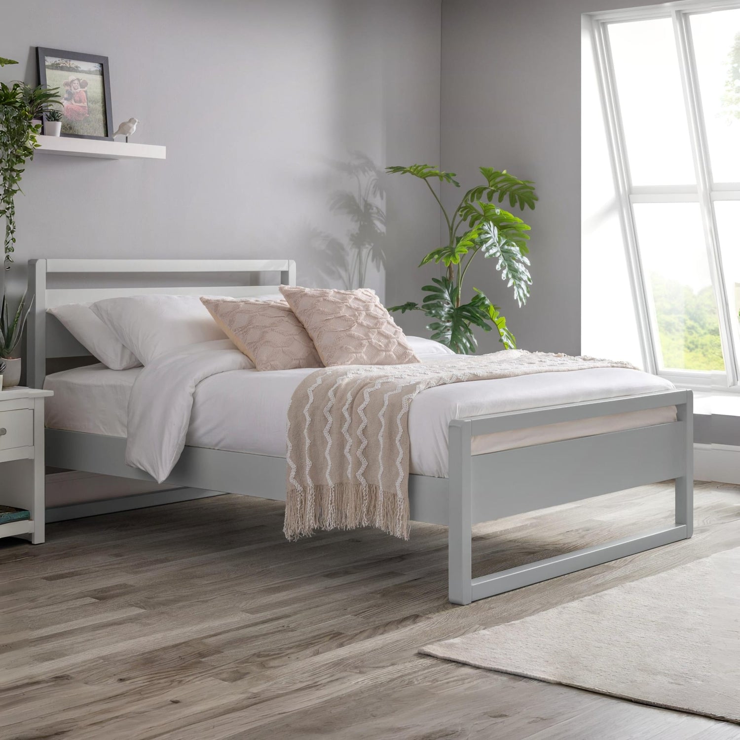 Bedroom with a gray bed frame, white bedding, and decorative pillows.