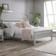 Bedroom with a gray bed frame, white bedding, and decorative pillows.