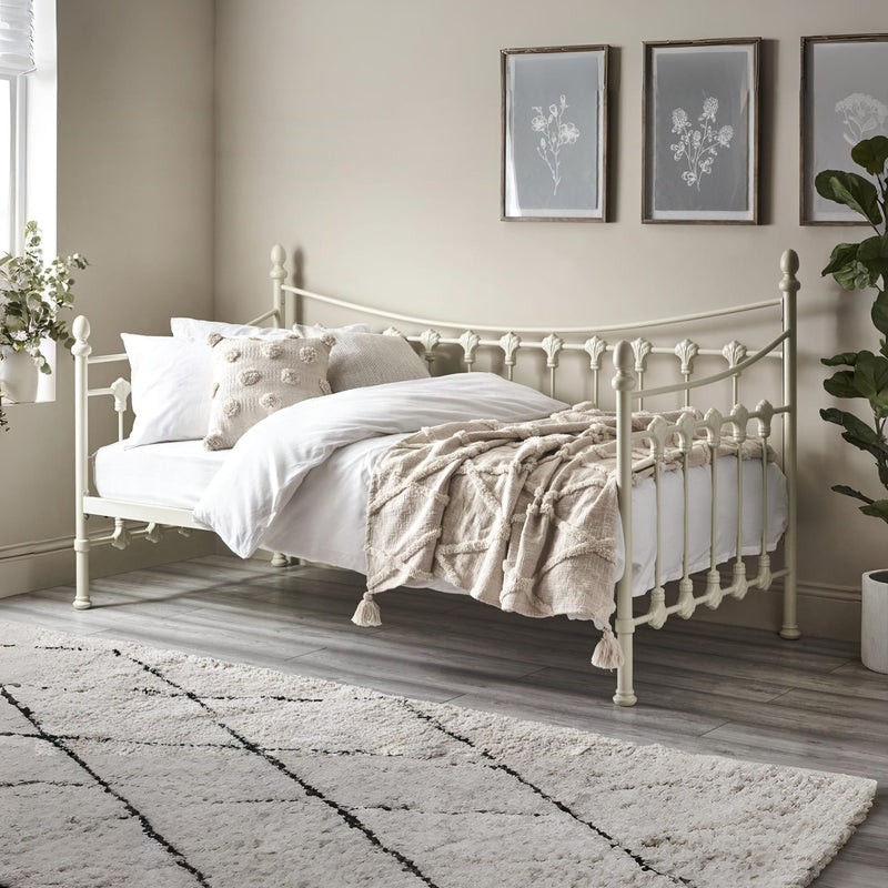 Neatly made bed with decorative pillows and a blanket in a bedroom setting.