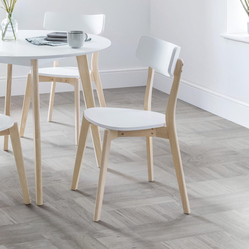 Dining table with chairs in a room with a light wooden floor.