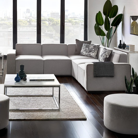 Modern living room with a sectional sofa, coffee table, and decorative items.