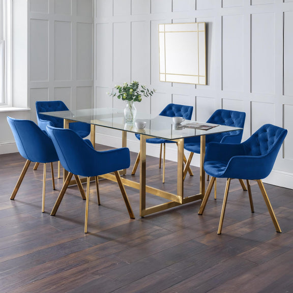 Dining room with a glass table and blue chairs on a wooden floor.