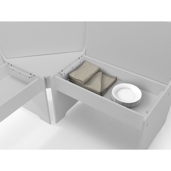White storage unit with open compartment containing folded clothes and plates on a white background
