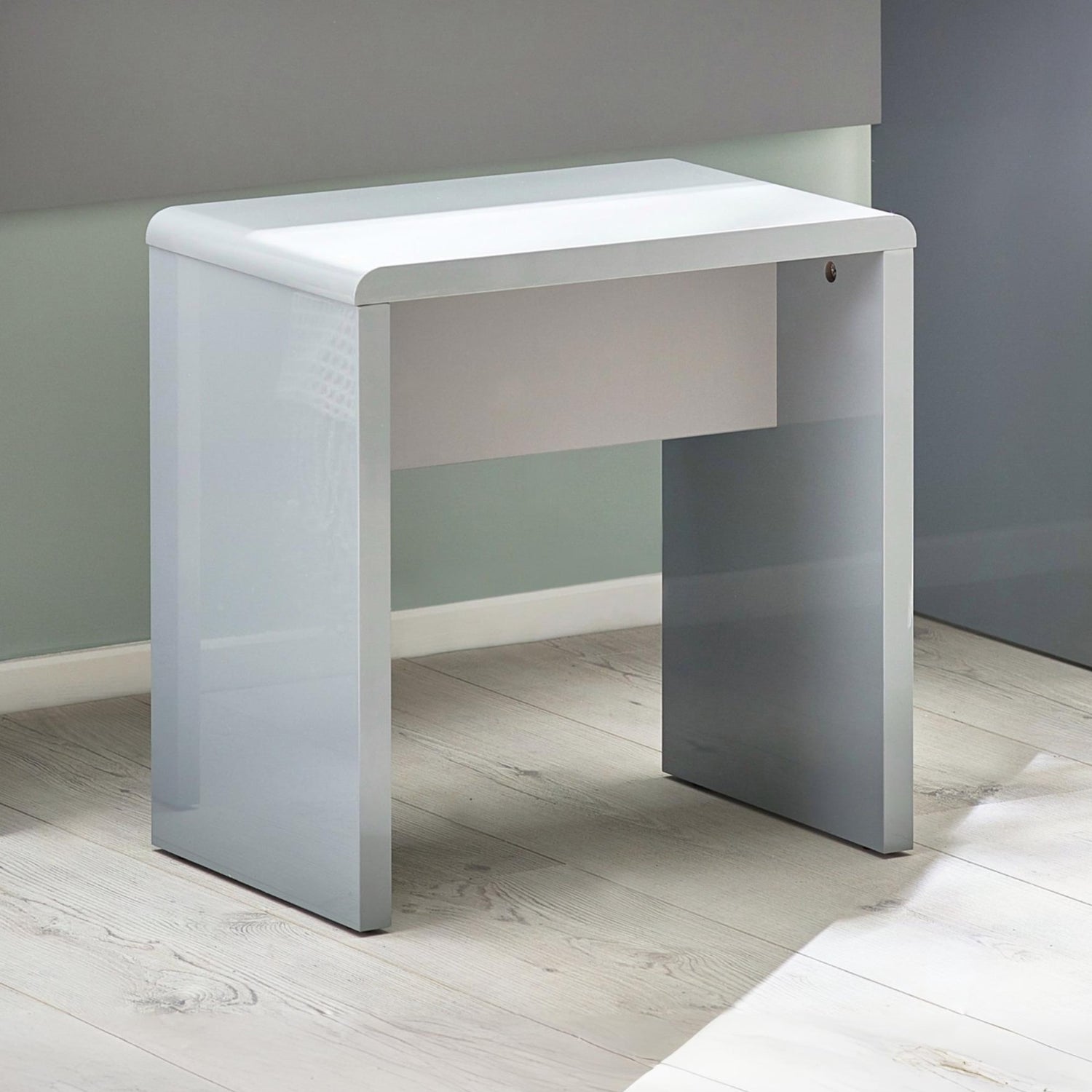 White desk against a gray wall on a light wooden floor