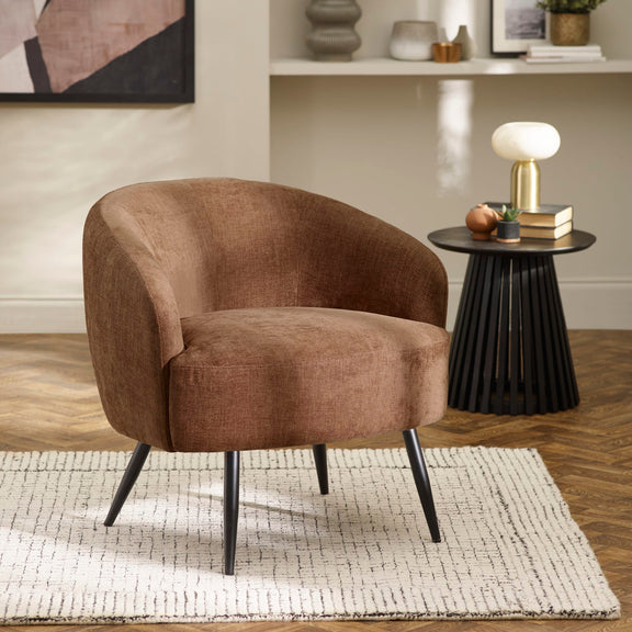 Brown armchair in a living room setting with a side table and decor items.