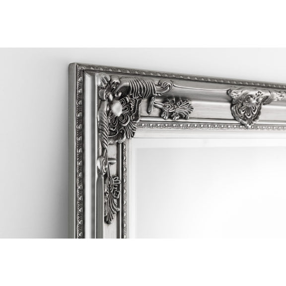 Decorative silver mirror with intricate designs on a white background
