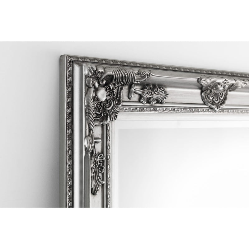 Decorative silver mirror with intricate designs on a white background