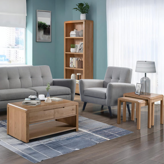 Living room with gray sofa, armchair, wooden coffee table, and bookshelf.